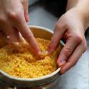 Close-up image showing hands carefully crafting a cosmetic product in a bowl
