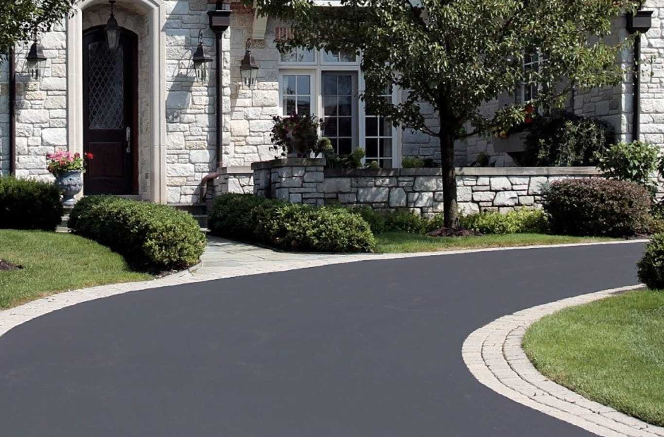 An employee from FARE Outdoor Construction working on driveway paving in Hoover, AL.